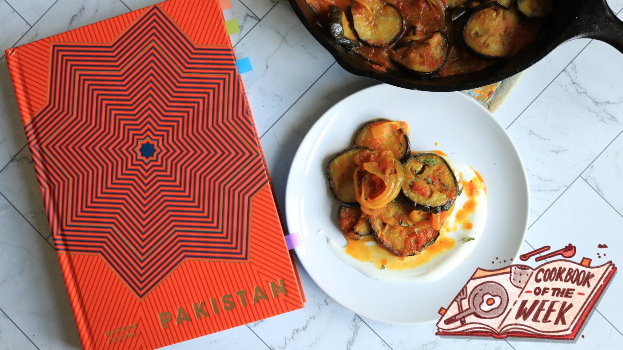 'Pakistan' cookbook on a counter next to an eggplant dish.