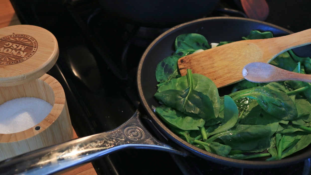 A skillet of spinach with a sprinkle of MSG.