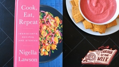 Cook, Eat, Repeat cookbook on a table next to a bowl of pink dip.