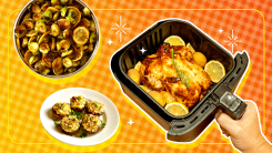 An air fryer basket with a roasted chicken inside and vegetables on a plate floating nearby.