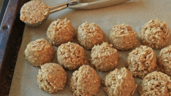 Raw oatmeal cookie dough balls closely arranged on a cookie sheet