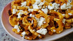A platter of sliced delicata squash with white cheese.