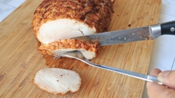 A photo of a knife cutting through a pork roast