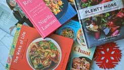 Cookbooks piled haphazardly on a countertop.