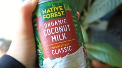 A hand holding a can of coconut milk.