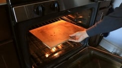 Allie putting a baking stone into the oven.