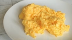 Scrambled eggs on a white plate.