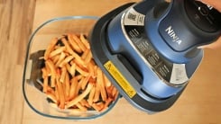 A Ninja Crispi air fryer with French fries inside.