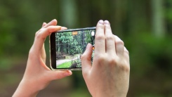 person taking photo outside with iPhone