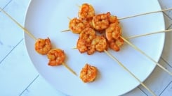 Spicy marinated shrimp on skewers on a plate.