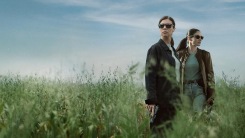 Two women stand in a field in a still from When No One Sees Us