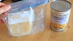 A can of chickpeas next to a zip-top bag of frozen chickpea liquid.