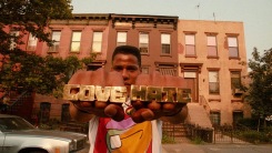 A man holds up hands displaying rings reading "Love" and "Hate"