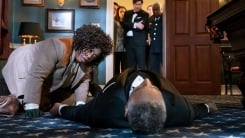 Detective Cupp looks over a body in a scene from The Residence