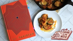 'Pakistan' cookbook on a counter next to an eggplant dish.