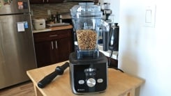 A Vitamix Ascent X5 blender with nuts inside on a countertop.