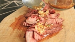 Seasoned oil sauce drizzled over thinly sliced steak