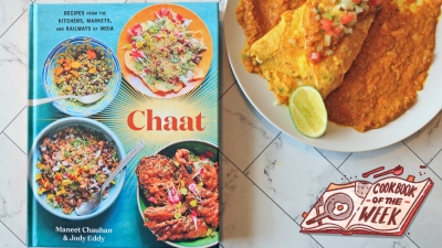 Chaat cookbook on a table next to an omelette with red sauce.