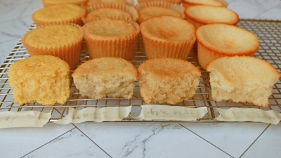 Four different types of cupcakes on a wire rack.