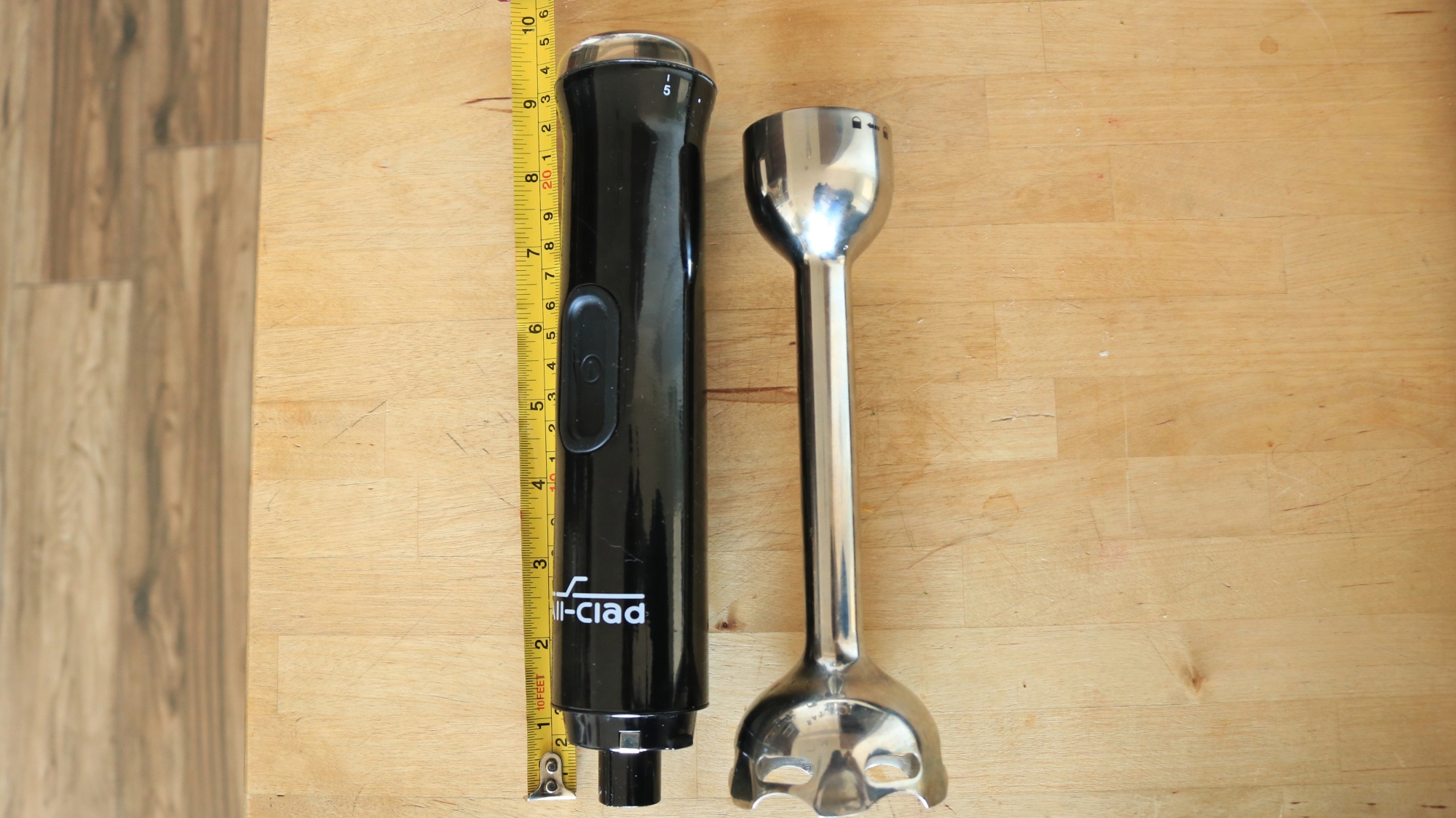 An immersion blender next to a tape measure to show height.