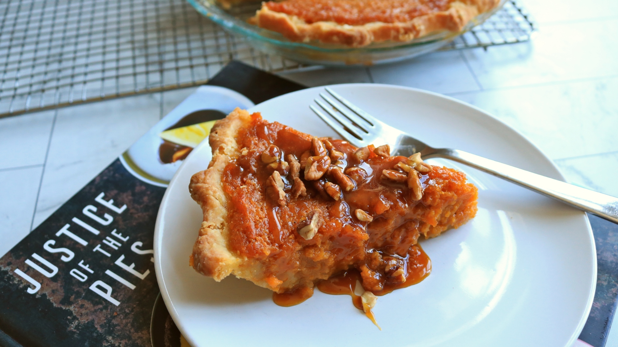 A slice of sweet potato pie on a cookbook.
