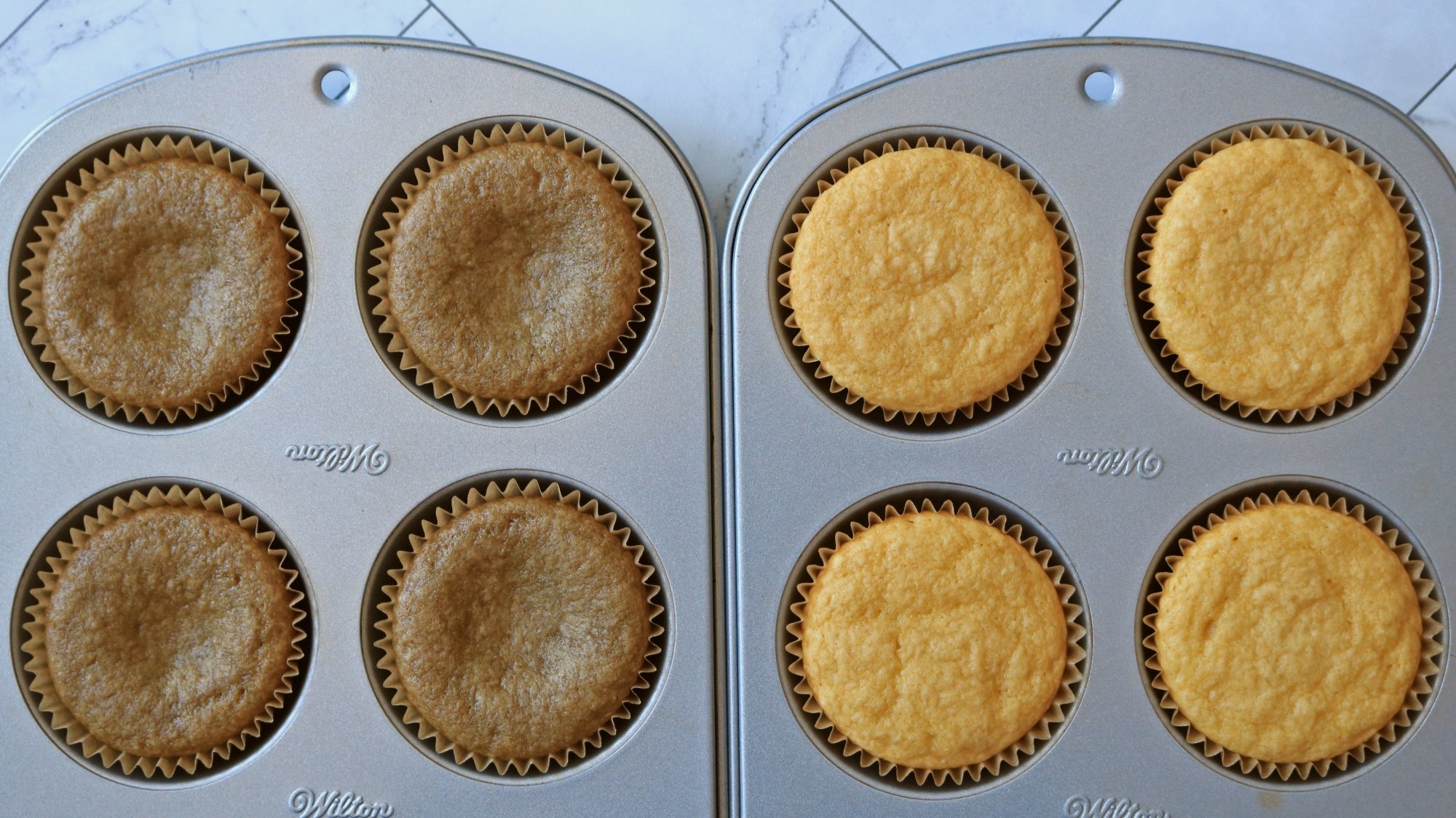 Two cupcake pans, one with brown cupcakes and one with yellow.