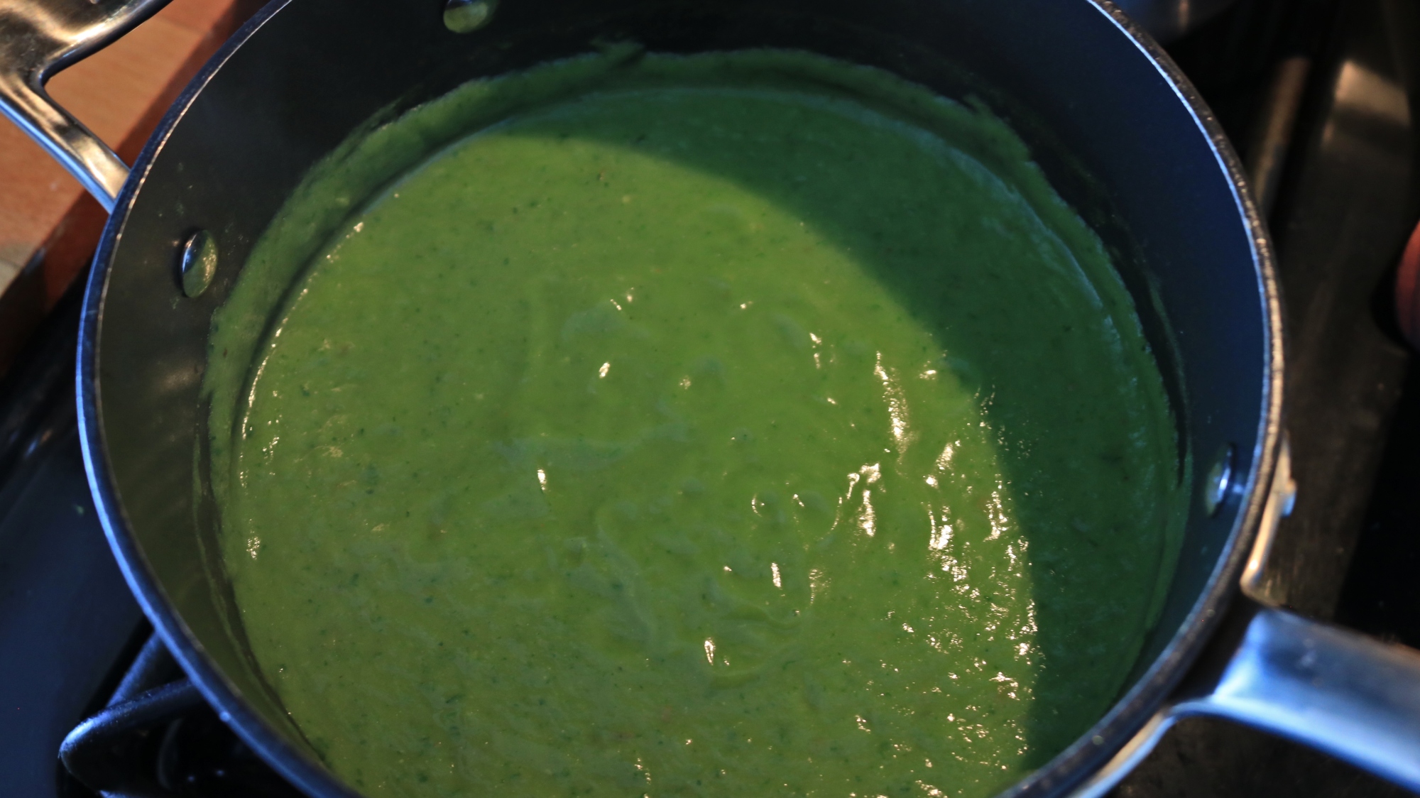 A pot of green broccoli soup.