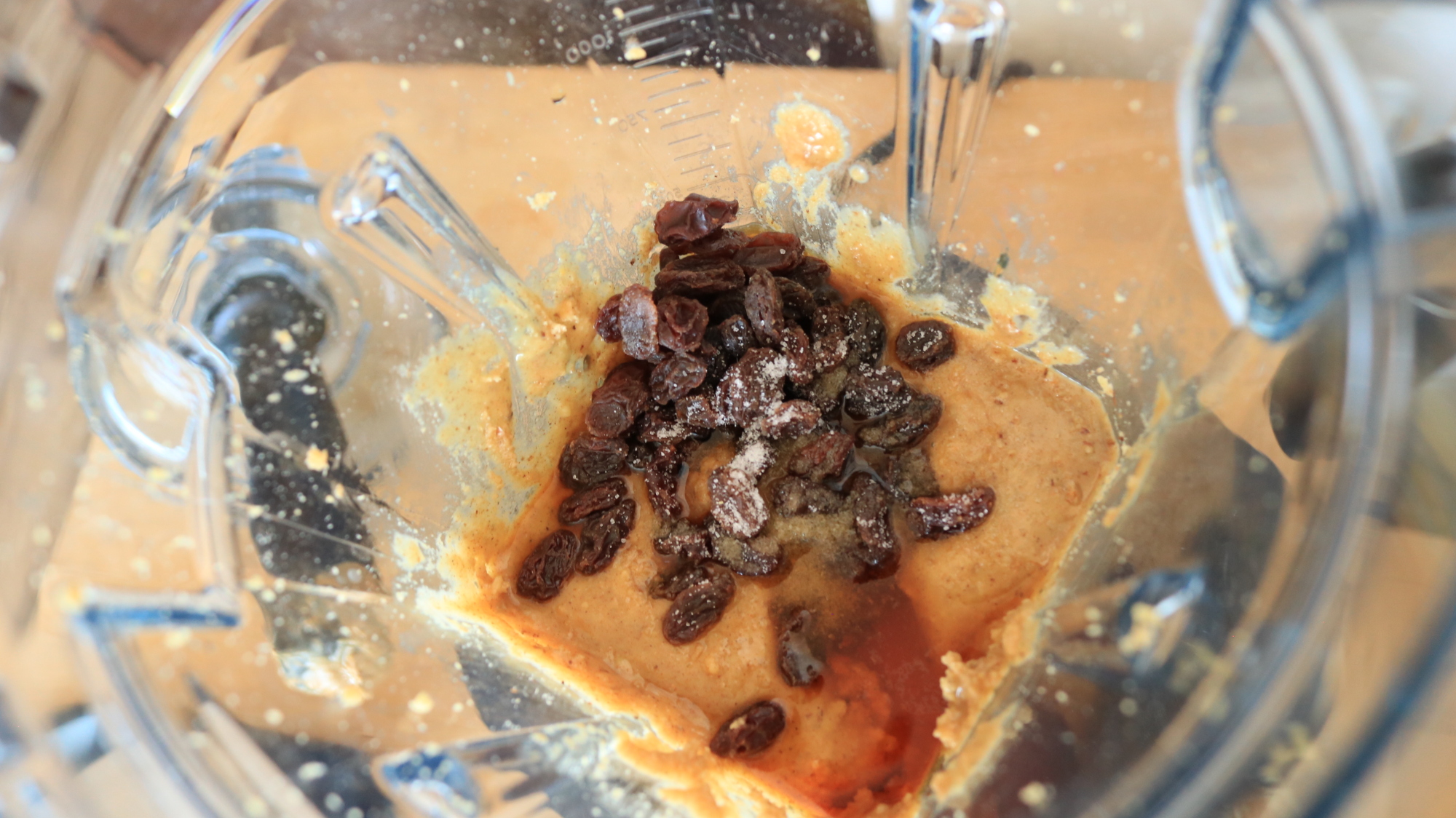 Walnut butter with rum and raisins in a blender container.