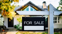"For Sale" sign in front of house.
