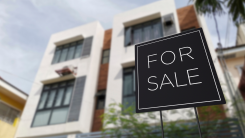 For sale sign in front of apartment complex.