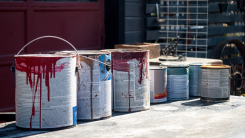 old leftover paint cans lined up on a sidewalk