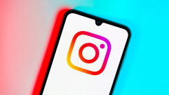 Instagram logo on a smartphone against a colorful gradient background.