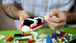 A candidate assembling LEGO bricks in a LEGO Master Builder competition
