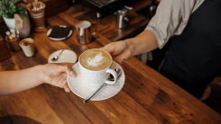 Barista hands over latte.