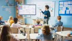 teaching using interactive white board in classroom with students