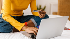 Woman holding credit card while making a purchase via her laptop
