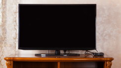 tv on a wooden tv stand, turned off