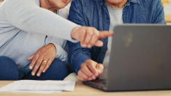 Couple on laptop pointing at screen,