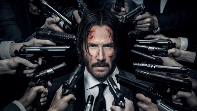 John Wick with guns pointed at him