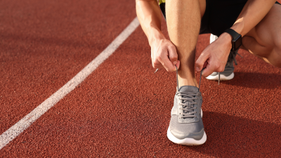 Man lacing up sneakers.