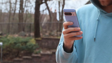A man looking at a Google Pixel Android phone outside